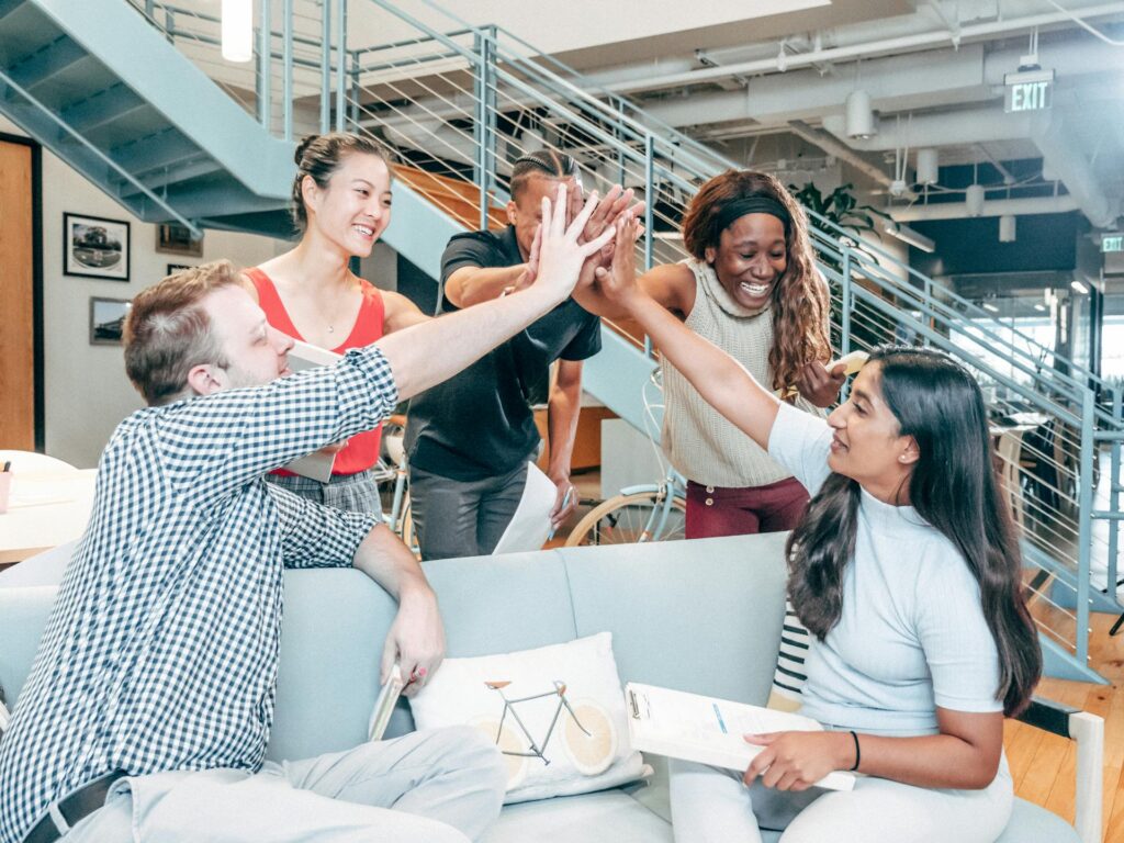 Happy group of people putting their hands together in an office