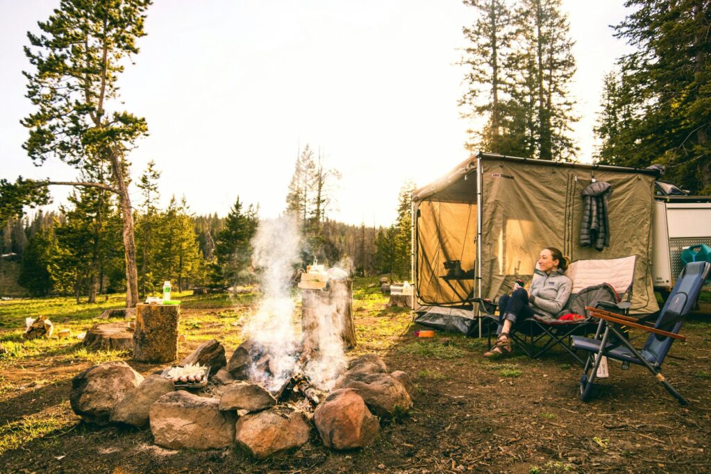 Woman camping next to a camp fire