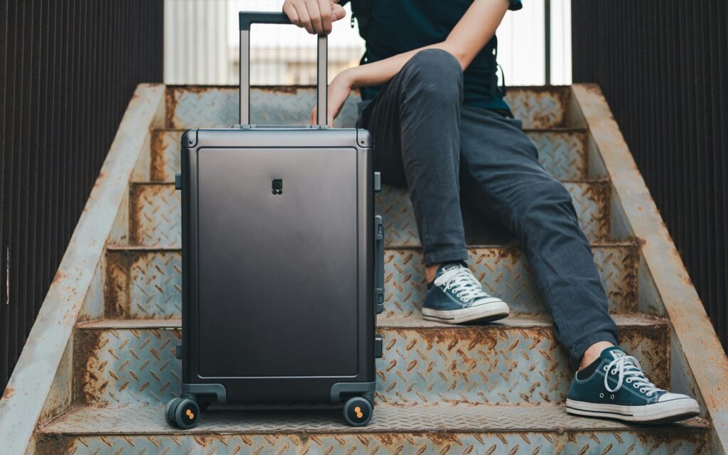 Man sitting on step with luggage